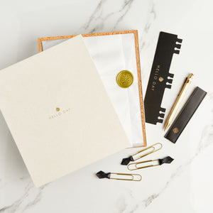 Hello Day Day Dreamer Bundle Planner in tissue paper with gold seal inside cream box with bookmark, pen and paperclips 