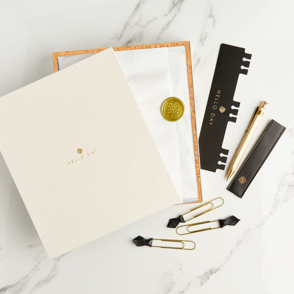 Hello Day Day Dreamer Bundle Planner in tissue paper with gold seal inside cream box with bookmark, pen and paperclips 